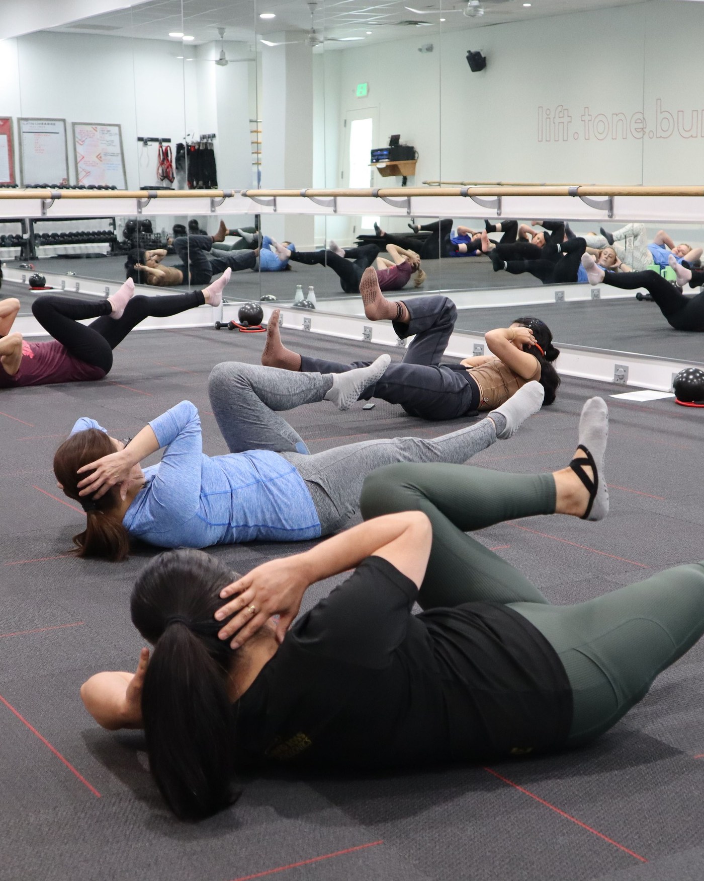 Clase de abdominales en grupo sobre colchonetas